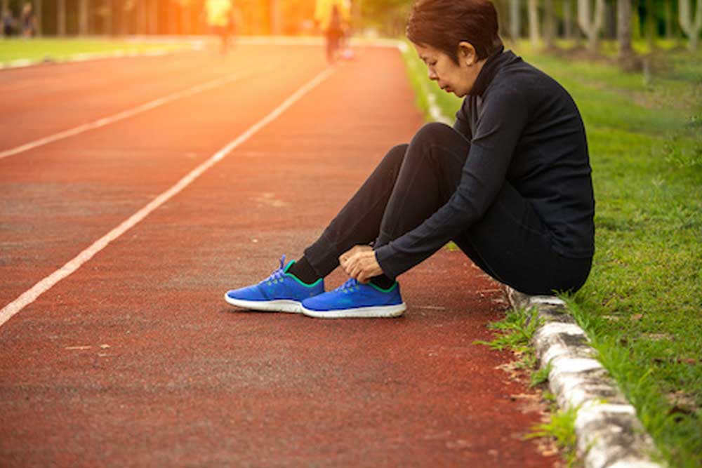 Woman putting on running shoes